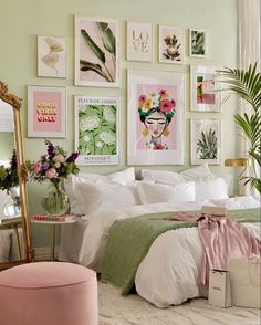 a bedroom with green walls and pictures on the wall above the bed, along with a pink ottoman