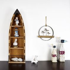 a shelf with some figurines sitting on it next to a wall mounted clock