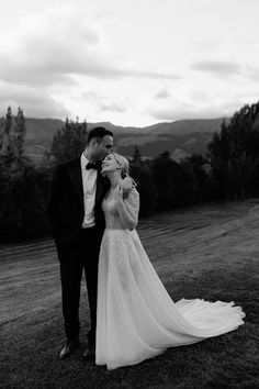 a man and woman standing in the grass