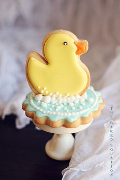 a decorated cookie in the shape of a rubber duck sitting on top of a table