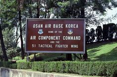 there is a sign that says osan air base korea home of the air component command and the 51 tactical fighter wing