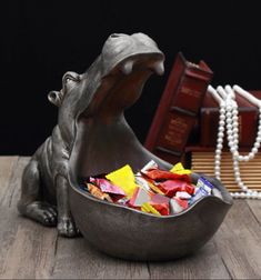 a statue of a hippopotamus in a bowl filled with candy and pearls