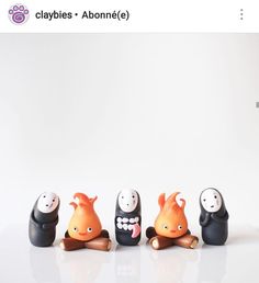 three small figurines are sitting in front of each other