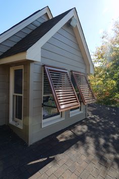 a small house with two windows and shutters