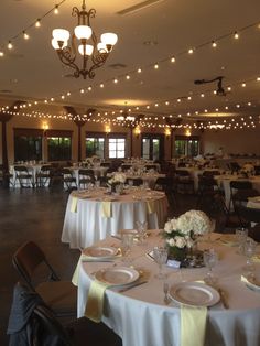 a banquet hall with tables and chairs covered in white tablecloths