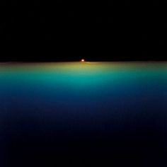 an orange ball floating on top of the ocean in the middle of dark blue water