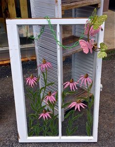 pink flowers are growing out of an old window