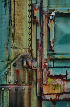 an old rusted metal door with rivets on it