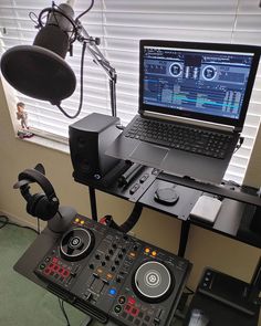 a laptop computer sitting on top of a desk next to a sound mixing equipment set up