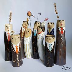 a group of wooden figurines with flowers in their heads and clothes on them