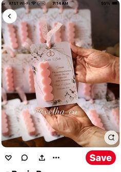 someone is holding up some pink wedding favors