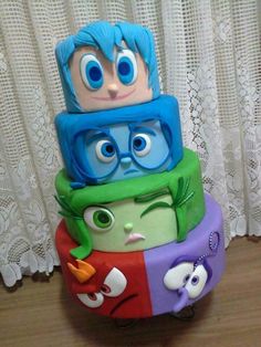 a stack of colorful cakes sitting on top of a wooden table