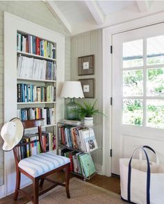 a room with a chair, bookshelf and lamp on the wall next to it