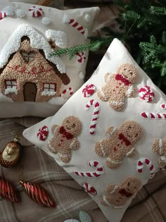 two christmas pillows with gingerbread decorations on them