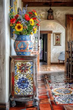 a vase filled with colorful flowers sitting on top of a wooden table next to a doorway