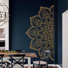 a dining room with a table and chairs next to a wall painted in dark blue