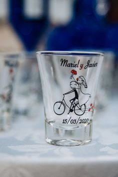 a shot glass with a bicycle on it sitting on a table next to other glasses