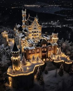 an aerial view of a castle lit up at night with christmas lights in the foreground