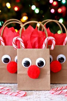 two paper bags decorated like reindeers with candy canes