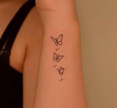 a woman's arm with three butterfly tattoos on the left side of her arm