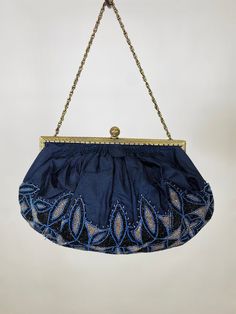 Antique Silk evening purse with French Steel-Cut Micro Glass Beads Purse in blue, silver, and black. The silk is in very good vintage condition, and the gold tone frame is detailed all around and works well. To open the purse tilt the filigree ball back and the closure will unlock. A beaded appliqué covers the majority of the purse, and the silk is gently gathered into the frame. On close inspection you can see some areas where the stitching was reinforced. This would be easy to remove or repair Blue Embellished Evening Bag For Formal Occasions, Elegant Beaded Evening Bag For Vintage Events, Formal Blue Embellished Bags, Blue Beaded Evening Bag For Formal Occasions, Formal Blue Embellished Evening Bag, Blue Beaded Evening Bag For Party, Vintage Blue Bags For Wedding, Vintage Blue Bag For Wedding, Vintage Blue Evening Bag For Formal Occasions