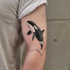 an orca whale tattoo on the arm