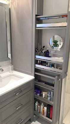 a bathroom with gray cabinets and white counter tops is shown in this image, there are several items inside the cabinet