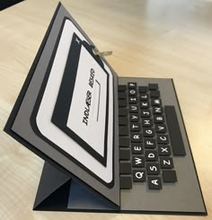 an open laptop computer sitting on top of a wooden table next to a calculator