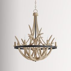 the antler chandelier is made from wood and has five candles in it