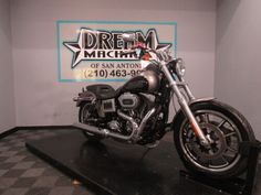 a motorcycle is on display in a showroom with a sign behind it that says dream machine