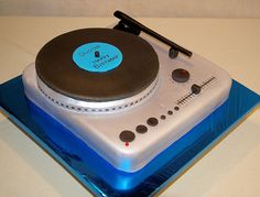 a cake made to look like a turntable on top of a blue plate with a black stick sticking out of it