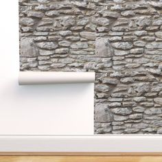 a stone wall with a white shelf in front of it