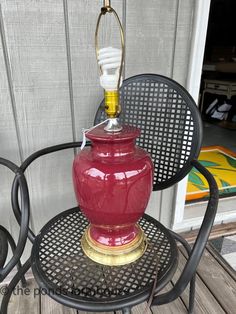 a red vase sitting on top of a metal chair