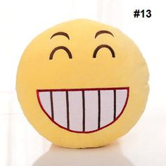 a yellow smiley face pillow sitting on top of a white table