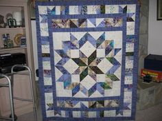 a blue and white quilt hanging on a wall