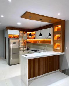 a kitchen with an island, refrigerator and sink in it's center area is lit by recessed lighting