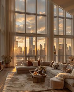 a living room filled with lots of furniture and large windows overlooking the cityscape