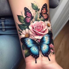 a woman's arm with flowers and butterflies on it, while she has a pink rose in the middle