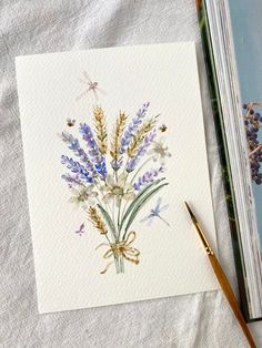 two watercolor paintings of lavenders and dragonflies on paper next to a paintbrush