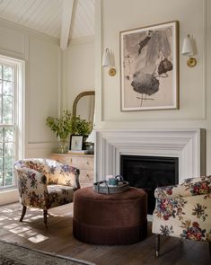 a living room filled with furniture and a fire place in front of a painting on the wall