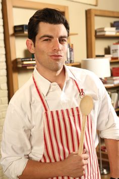 a man in an apron holding a wooden spoon