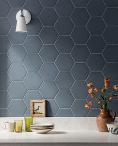 a kitchen counter with plates, cups and vases sitting on it's side