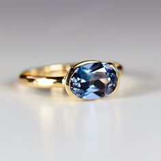 This beautiful oval lab grown color change sapphire ring was made of 8mmx6mm oval sapphire stone in 14k gold half bezel bezel setting and 14k yellow gold 2mm hammered band. It's perfect as a solitaire engagement ring or statement ring. DETAILS Ring Band: 14K YELLOW GOLDRing Band size: 2mm wide x 1mm thick half roundRing Band is hammered or smooth by requested.Gemstone: Lab grown color change sapphireGemstone size and cut: 6x8mm oval cutCarat weight : 1.25 ct. weightGemstone Quality : AAA *** All Half Bezel Sapphire Ring, East West Oval Sapphire Ring, Modern Sapphire Engagement Ring, Bezel Set Gemstone Ring, Bezel Sapphire Ring, Bezel Sapphire Engagement Ring, East West Half Bezel, Thick Engagement Rings, Sapphire Bezel Ring