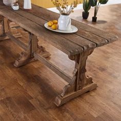 a wooden table with two vases and some lemons on the plate next to it