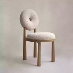 a white chair with a donut shaped seat on it's back and legs