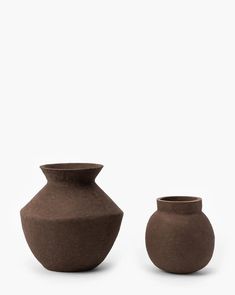 two brown vases sitting next to each other on a white surface with no one around them