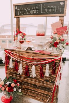 a wooden box with red and white decorations on it next to a sign that says kissing booth