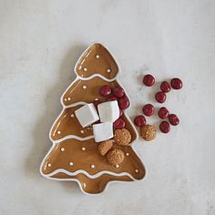 a christmas tree shaped platter with marshmallows and cranberries next to it