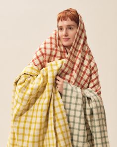 a young woman wrapped in a plaid blanket