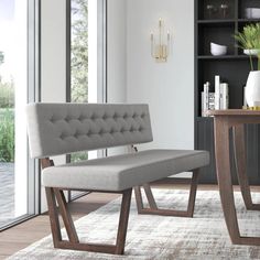 a gray bench sitting on top of a wooden table